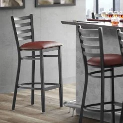 Lancaster Table & Seating Black Finish Ladder Back Bar Stool With 2 1/2" Burgundy Vinyl Padded Seat
