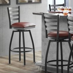 Lancaster Table & Seating Black Finish Ladder Back Swivel Bar Stool With 2 1/2" Burgundy Vinyl Padded Seat