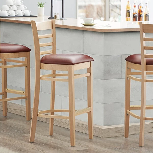 Lancaster Table & Seating Natural Ladder Back Bar Height Chair With 2 1/2" Burgundy Padded Seat 1 Lancaster Table & Seating Natural Ladder Back Bar Height Chair With 2 1/2" Burgundy Padded Seat