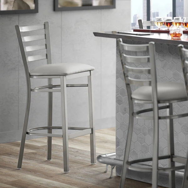 Lancaster Table & Seating Clear Coat Finish Ladder Back Bar Stool With 2 1/2" Light Gray Vinyl Padded Seat 1 Lancaster Table & Seating Clear Coat Finish Ladder Back Bar Stool With 2 1/2" Light Gray Vinyl Padded Seat