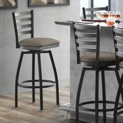 Lancaster Table & Seating Black Finish Ladder Back Swivel Bar Stool With 2 1/2" Taupe Vinyl Padded Seat