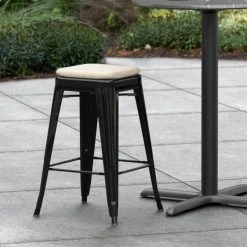 LT&S Alloy Series Lancaster Table & Seating Alloy Series Black Stackable Metal Indoor / Outdoor Industrial Cafe Counter Height Stool With Tan Fabric Magnetic Cushion