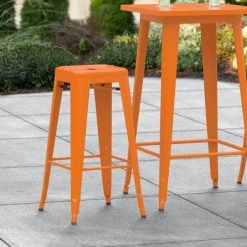 LT&S Alloy Series Lancaster Table & Seating Alloy Series Orange Stackable Metal Indoor / Outdoor Industrial Barstool With Drain Hole Seat