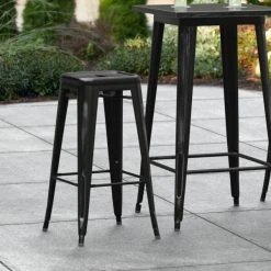 LT&S Alloy Series Lancaster Table & Seating Alloy Series Distressed Black Stackable Metal Indoor / Outdoor Industrial Barstool With Drain Hole Seat