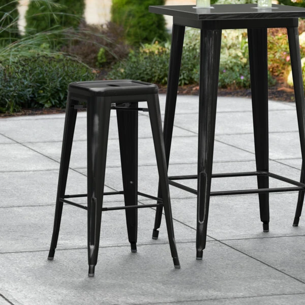LT&S Alloy Series Lancaster Table & Seating Alloy Series Distressed Black Stackable Metal Indoor / Outdoor Industrial Barstool With Drain Hole Seat 1 LT&S Alloy Series Lancaster Table & Seating Alloy Series Distressed Black Stackable Metal Indoor / Outdoor Industrial Barstool With Drain Hole Seat