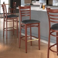 LT&S Spartan Series Lancaster Table & Seating Spartan Series Bar Height Metal Ladder Back Chair With Mahogany Wood Grain Finish And Black Vinyl Seat