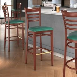 LT&S Spartan Series Lancaster Table & Seating Spartan Series Bar Height Metal Ladder Back Chair With Mahogany Wood Grain Finish And Green Vinyl Seat