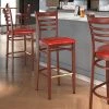 LT&S Spartan Series Lancaster Table & Seating Spartan Series Bar Height Metal Ladder Back Chair With Mahogany Wood Grain Finish And Red Vinyl Seat