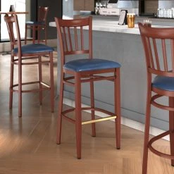 LT&S Spartan Series Lancaster Table & Seating Spartan Series Bar Height Metal Slat Back Chair With Mahogany Wood Grain Finish And Navy Vinyl Seat